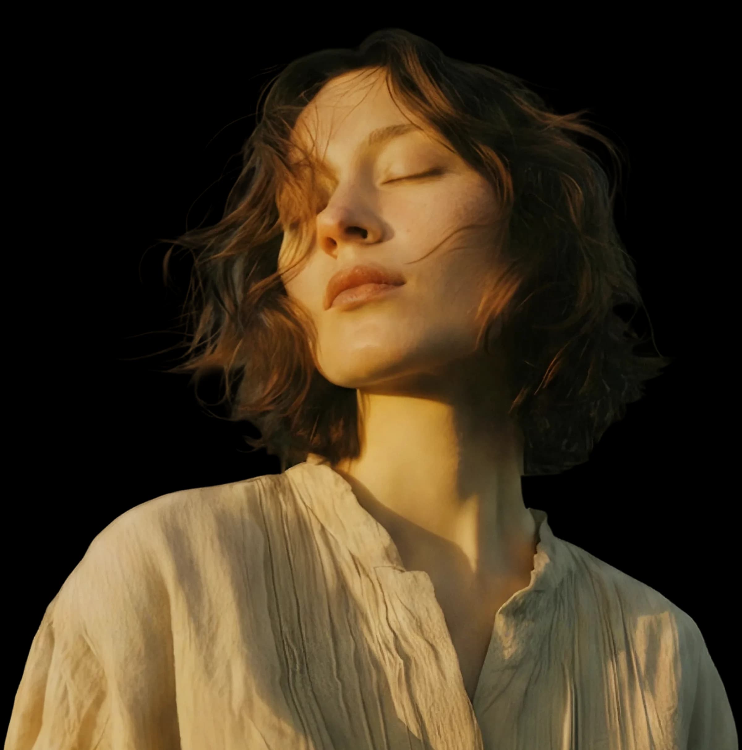 A woman with her eyes closed, bathed in warm sunlight